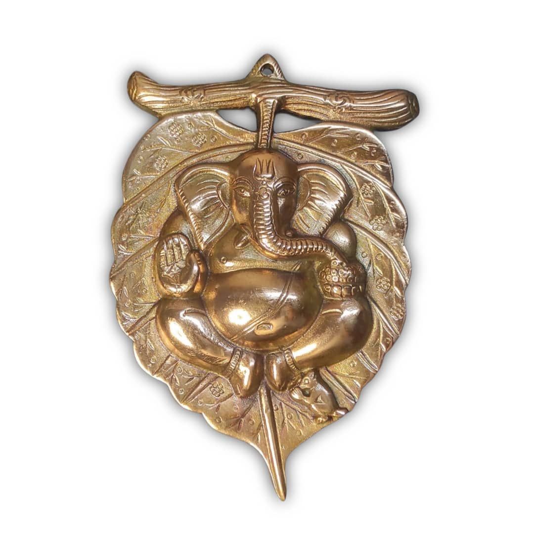 Ganeshji back leaf God idol Metal murti on the wall.