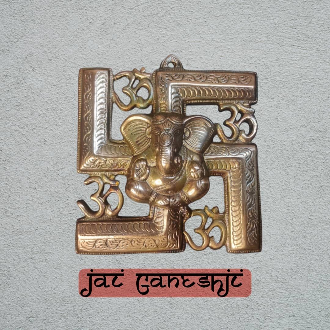 Ganeshji back swastik & om God idol Metal murti on the wall.