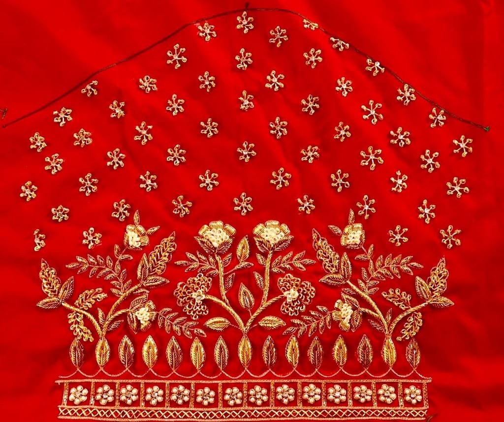 Red and gold embroidered blouse with intricate floral and leaf motifs, featuring a deep U-shaped neckline and pearl and sequin embellishments.