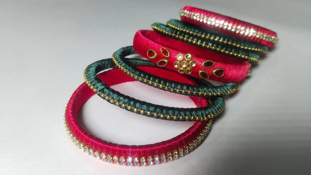 Red and green silk thread bangles with stone and pearl embellishment