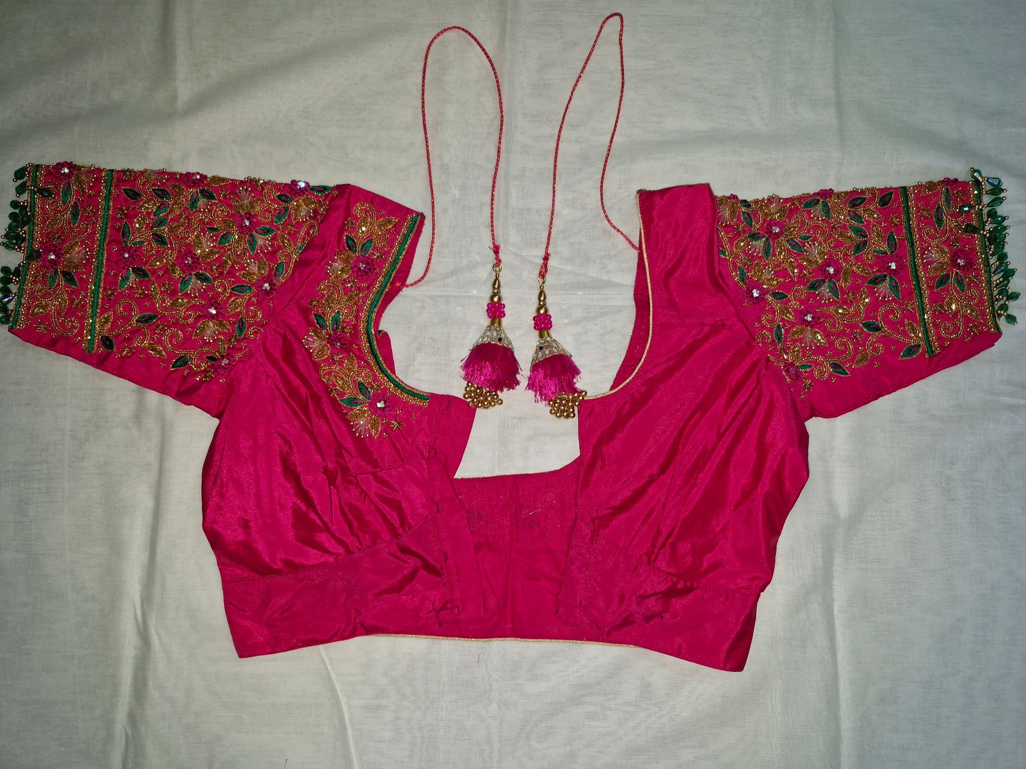 Embroidered magenta pink silk readymade blouse with green and gold threadwork