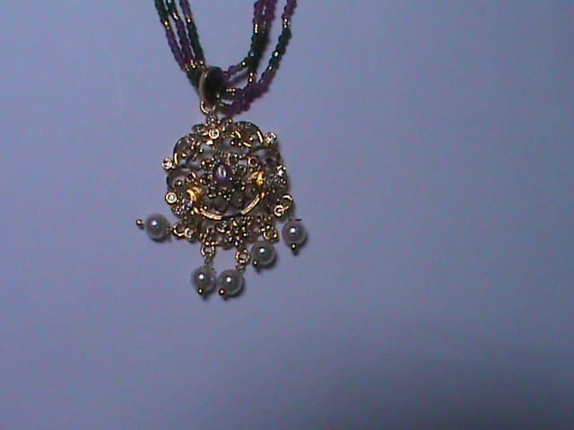 Black beaded necklace with golden pendant and pearl accents