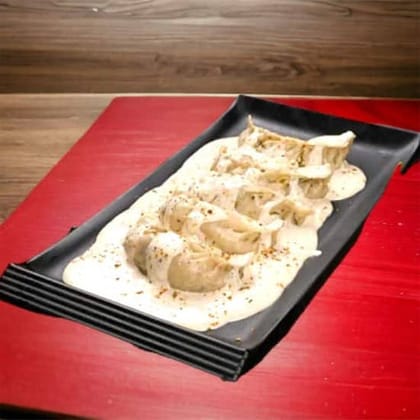 Paneer Wheat Momos In Molten Cheese Sauce