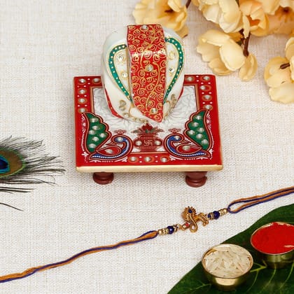 Designer Mor Pankh with Flute Rakhi with Lord Ganesha on Marble Chowki and Roli Chawal Pack