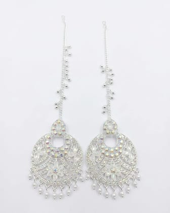 Vardaan Crystalx These stunning silver chandelier jhumkas feature intricate filigree, shimmering iridescent crystals, pearl drops, and long dangling chains for elegant everyday glamour.