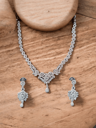 Crafted in 14k white gold, this stunning necklace and earring set features round and pear shaped cubic zirconia stones.