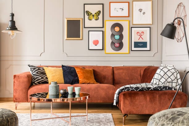Velvet sectional sofa with chaise lounge in burnt orange color. Modern living room furniture.