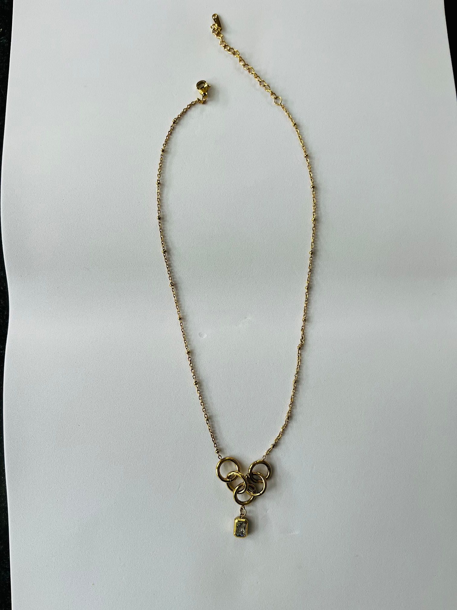 Elegant Gold-Toned Intertwined Rings & Crystal Pendant Necklace