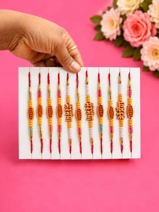 Celebrate Raksha Bandhan with this elegant set of 12 lotus design rakhis. Featuring pearl-like beads, yellow accents, and red-yellow threads for a festive traditional look.