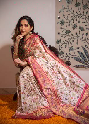 Rani Baagh: Double Ikat Patan Patola Saree And Meenakari Banarasi Border With Mughal Butas In The Shades Of White And Pink