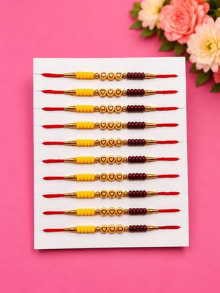 Celebrate Raksha Bandhan with this elegant set of 12 lotus design rakhis. Featuring pearl-like beads, yellow accents, and red-yellow threads for a festive traditional look.