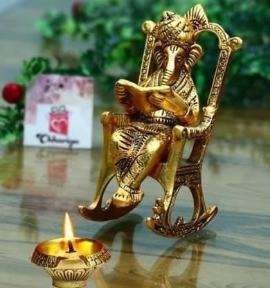 Golden Lord Ganesha Statue Sitting On A Rocking Chair And Reading Ramayan Showpiece - Pooja Needs | Buy online on ZillyBuy